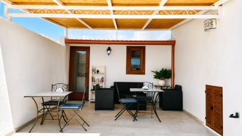 Terrazza dell'appartamento Malvasia Liquoroso a Casa Giuliana e Malvasia 70, Lipari, con pergolato in legno, sedute e vista sul mare