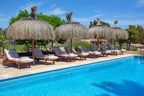 Piscine de l'Agroturismo Ses Illes avec parasols de chaume, transats et jardin à Costitx, Espagne