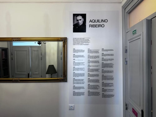 Quarto 101 Aquilino Ribeiro no Santiago de Caminha Boutique Hostel com retrato e biografia em parede branca decorada