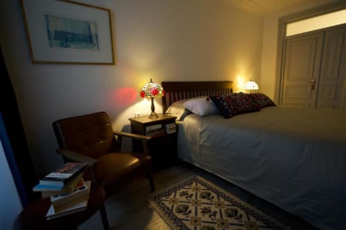 Quarto aconchegante na Pousada Boutique Santiago de Caminha em Caminha, Portugal, com cama e almofadas decorativas, ideal para leitura