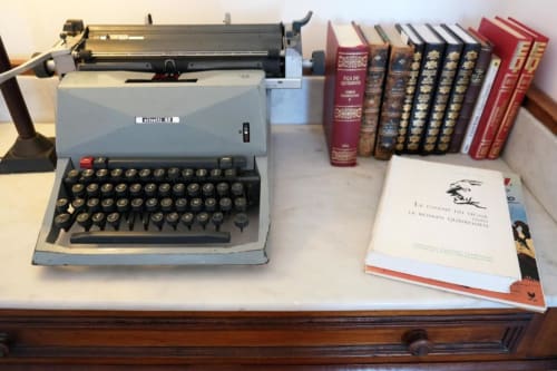 Máquina de escrever vintage e acervo de literatura portuguesa no quarto Eça de Queirós da Santiago de Caminha Boutique Hostel