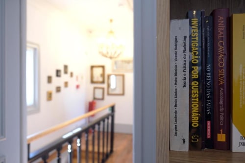 Estante com literatura portuguesa vista da escada no Boutique Hostel Santiago de Caminha, Caminha