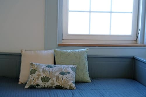 Aconchegante espaço junto à janela da Santiago de Caminha Boutique Hostel com almofada azul e almofadas decorativas com vista para o jardim