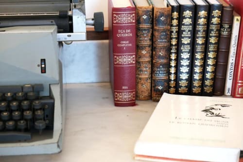 Máquina de escrever vintage ao lado da coleção de literatura clássica portuguesa no quarto Eça de Queirós em Santiago de Caminha Boutique