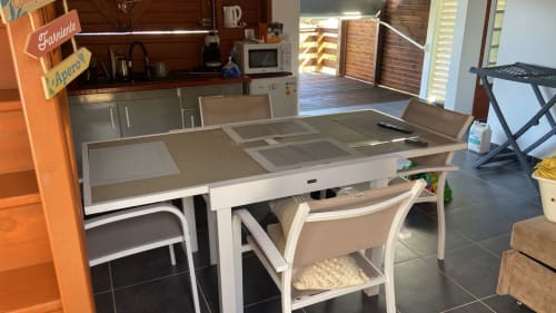 Table à manger moderne avec chaises blanches dans l'appartement KaZa Bel'Vi à la Résidence KaZa Lou-Lou, Guadeloupe, avec vue sur mer