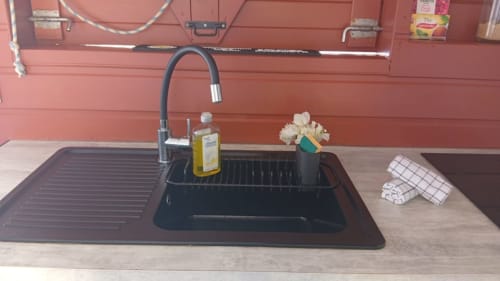 Évier de cuisine noir moderne avec robinetterie dans appartement de vacances à Capesterre de Marie-Galante, avec meubles rouges