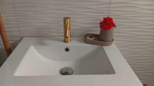 Lavabo de salle de bains moderne avec robinetterie dorée et décoration florale rouge à la Résidence KaZa Lou-Lou, Capesterre Marie-Galante