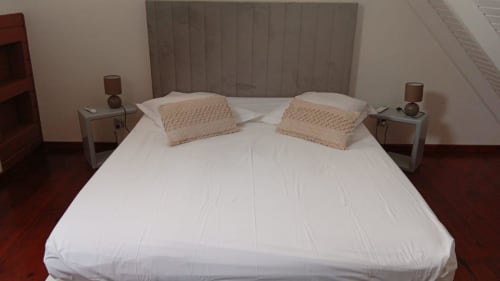 Chambre spacieuse avec draps blancs et coussins beige à la Résidence KaZa Lou-Lou, gîte Marie-Galante avec vue mer et moderne