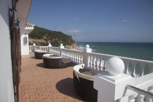 Terraza costera del Hostal Mar de Frente con balaustrada blanca, vistas al mar y paisaje mediterráneo en Los Caños de Meca