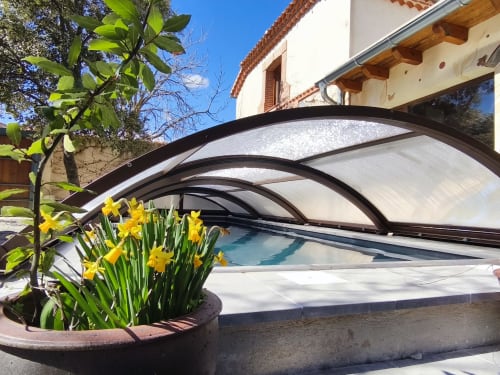 Piscine couverte de l'hôtel Viento de Ladera à Ségovie avec jonquilles jaunes et toit en polycarbonate arqué
