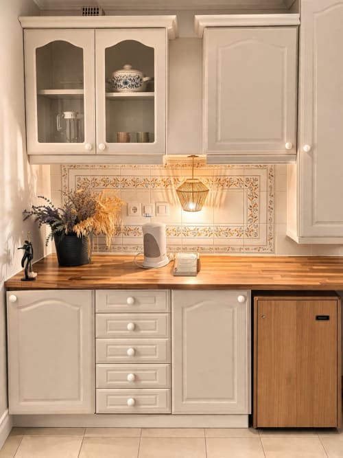 Cozinha elegante com tons creme, bancada em madeira, azulejos decorativos e frigorífico na Herdade da Cova da Onça