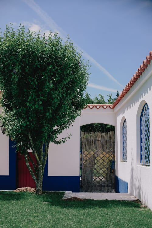 Exterior de casa de campo branca e azul com telhado de telhas vermelhas em Herdade da Cova da Onça, Canha, Portugal