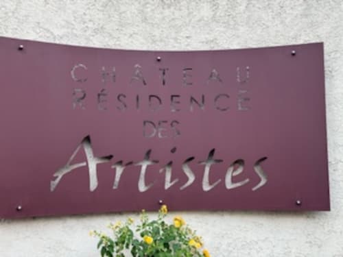 Tafel des Château Résidence des Artistes in Le Cannet mit gelben Blumen darunter