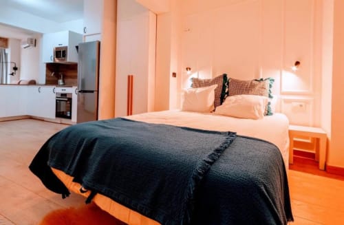 Acogedor apartamento estudio naranja en Mérida con cama, kitchenette y comodidades modernas incluyendo AC y WiFi