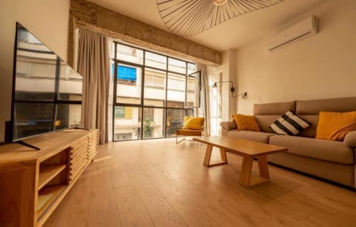 Amplio apartamento moderno en Gestyp-AT, Mérida, con sofá beige, muebles de madera, vista a la ciudad, aire acondicionado, TV y luz natural