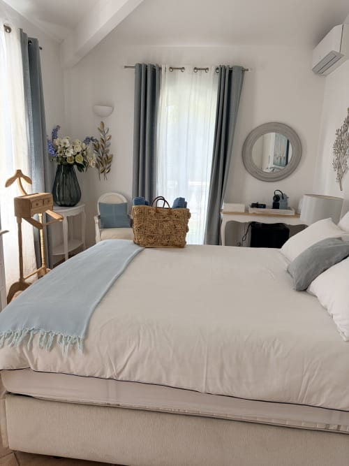 Helles Schlafzimmer in La Parenthèse de Villepey mit weißer Bettwäsche, grauen Akzenten und Gartenfensterblick in Saint Aygulf