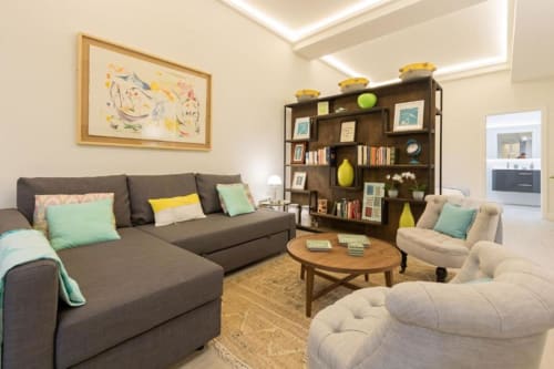 Sala de estar moderna en apartamento Calma Places Almirante Hoyos en Sevilla con sofá gris, sillas beige, mesa de madera y