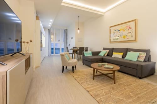 Apartamento Almirante Hoyos en Calma Places Sevilla con salón, sofá, sillón y balcón con vistas al mar