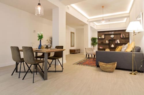 Apartamento Calma Places Almirante Hoyos en Sevilla con sala de estar diáfana, mesa de comedor, sofá gris y estantería