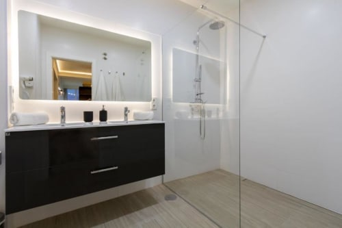 Baño moderno en apartamento Calma Places Almirante Hoyos en Sevilla con lavabo negro y ducha de cristal
