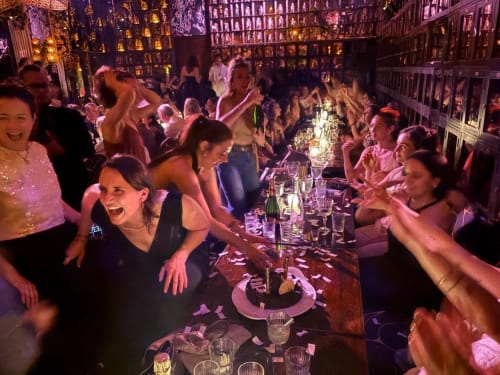 Guests celebrating at Riad 191 in Marrakech with dinner table, ambient lighting, and traditional riad architecture backdrop