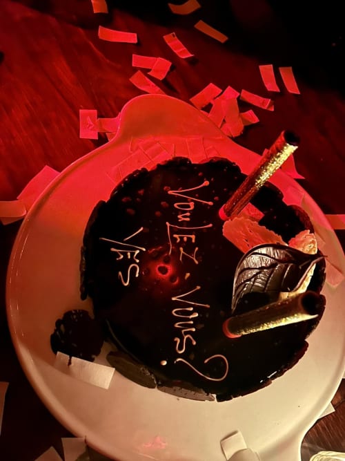 Chocolate heart cake with red decorations at Riad 191 Marrakech, adorned with a golden knife and romantic message