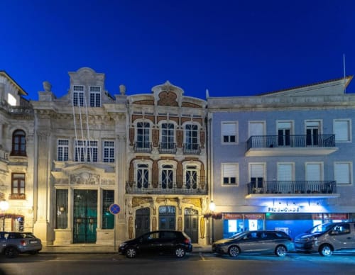 Edifícios históricos portugueses iluminados ao entardecer em Aveiro, com arquitetura ornamentada e fachada azulejar típica