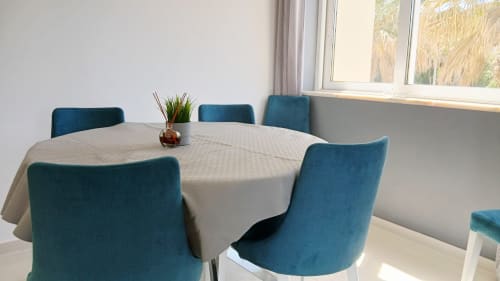 Sala de jantar no apartamento Sweet Home Amoreira, Portimão, com mesa redonda, cadeiras cor turquesa e vista para a cidade