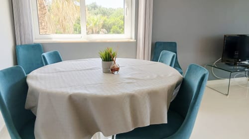 Sala de jantar do apartamento Sweet Home Amoreira em Portimão com mesa redonda, cadeiras turquesas e vista para o jardim