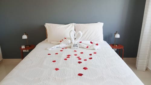 Quarto romântico do apartamento Sweet Home Amoreira em Portimão com pétalos de rosa na roupa de cama branca e cisnes de toalha