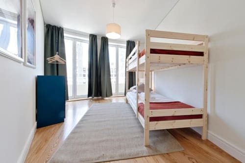 Bright apartment bedroom with wooden bunk bed, city view balcony, and modern amenities in Aveiro downtown center