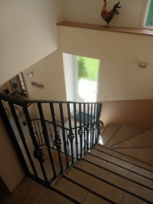 Staircase with black metal railing at Clos De La Gourmandiere B&B in Saint-Lothain, France