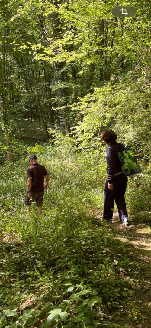 Hikers on a lush forest trail near Clos De La Gourmandiere in Saint-Lothain, France