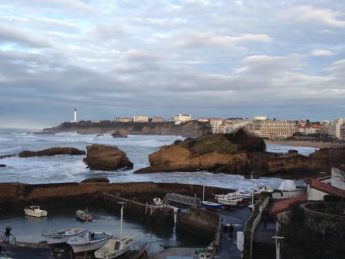 Port côtier avec bateaux de pêche, rochers et phare près de Biarritz, France