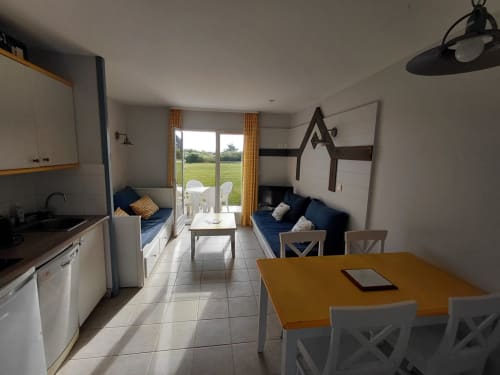 Intérieur moderne d'un appartement aux Locations Loc'Maria, Belle Île-en-Mer avec cuisine, salle à manger, salon et vue sur mer