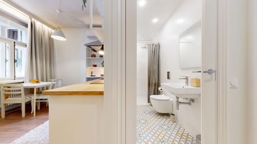 Bathroom in tARTu Stays apartment with toilet, sink, shower, and patterned tile floor in Tartu
