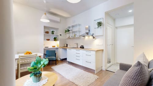 Modern apartment kitchen and living area at tARTu Stays in Tartu with white cabinetry, dining table, and comfortable seating.