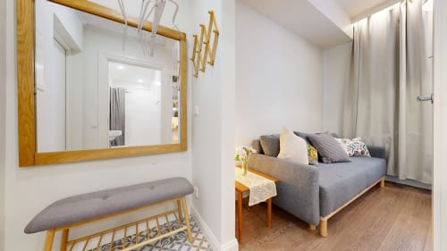 Modern apartment living area at tARTu Stays with gray sofa, wooden furniture, and mirror in Tartu city center