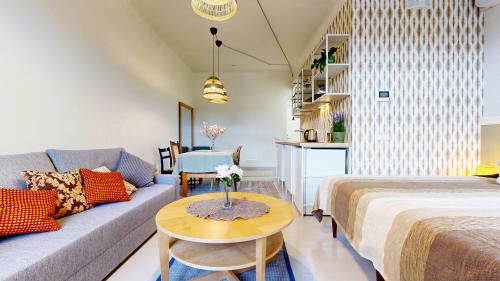 Modern studio apartment at tARTu Stays with gray sofa, yellow coffee table, and beds in Tartu city center