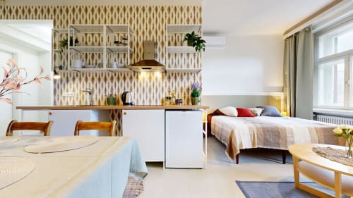 Modern studio apartment at tARTu Stays featuring kitchenette, dining area, and bed with city view in Tartu