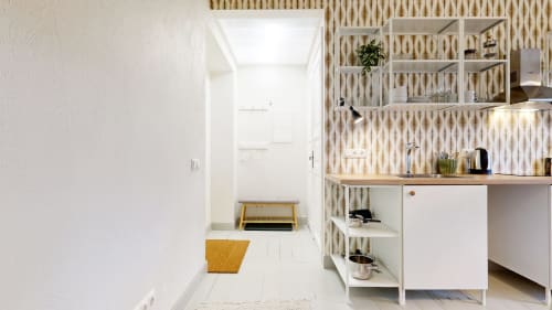 Modern kitchen in tARTu Stays apartment with white cabinetry, wooden countertop, open shelving, and striped backsplash in