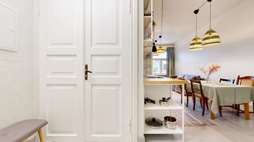 tARTu Stays apartment entrance showing dining area with pendant lights and kitchen setup in Tartu