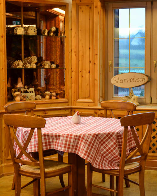 Salle à manger alpine douillette à l'Hôtel Des Vosges avec nappe à carreaux rouges, chaises en bois, vues montagne et style