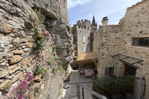 Mittelalterlicher Steinhof bei La Sarrasine in Aiguèze, Ferienunterkünfte im historischen Zentrum, nahe den Ardèche-Schluchten, mit fußläufigem Zugang zum Fluss, mit blühenden Wildblumen, historischen Türmen und möblierter Terrasse.
