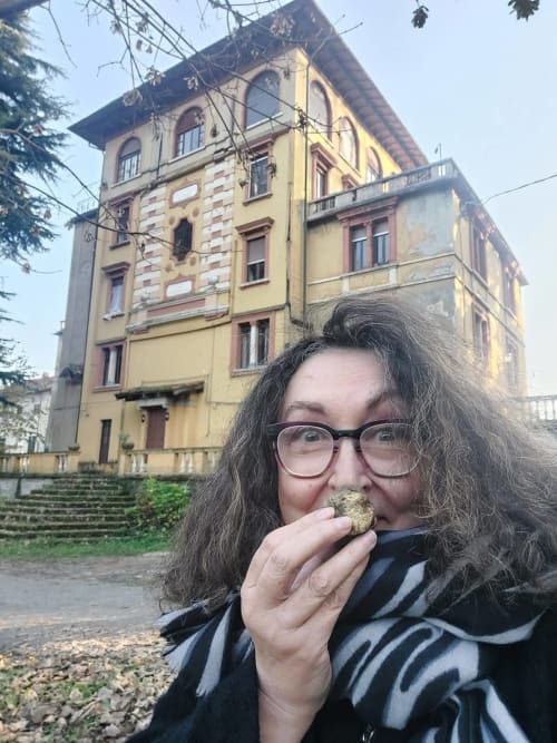 Hôte dégustant une pâtisserie locale à Palazzo Losio à Ponzone, Italie, avec vue sur la villa historique