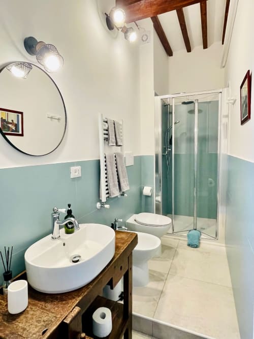 Moderno bagno nella camera Philosophy presso Agriturismo CasaViVa con lavabo bianco, doccia in vetro e dettagli verde menta