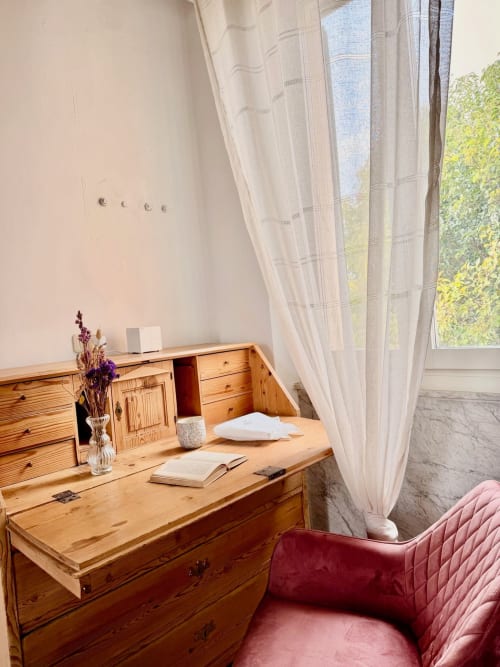 Scrivania in legno con vista sul giardino nella sala Filosofia di Agriturismo CasaViVa, Pozzo della Chiana, con sedia bordeaux e velo