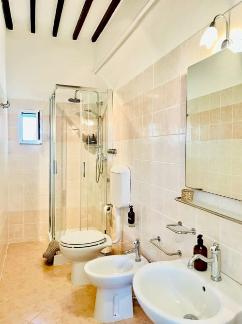 Bagno moderno all'Agriturismo CasaViVa con doccia in vetro, doppio lavabo, WC e bidet nella camera Profumo