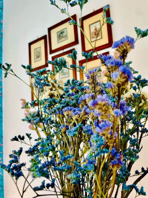 Fiori di campo blu incorniciano stampe botaniche presso l'Agriturismo CasaViVa a Pozzo della Chiana