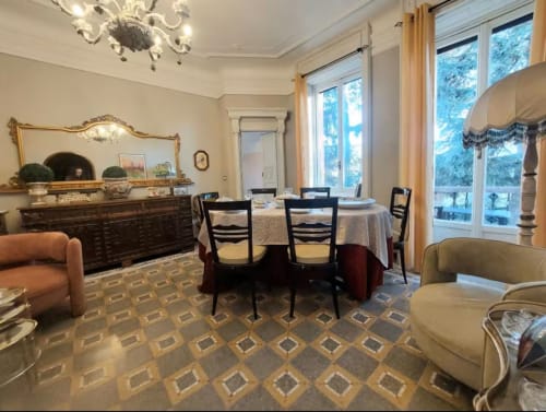 Salle à manger élégante au Palazzo Losio avec lustre orné, mobilier en bois foncé et grandes fenêtres sur Ponzone